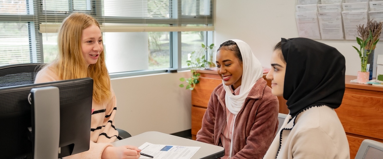 Two students sitting with a NOVA advisor