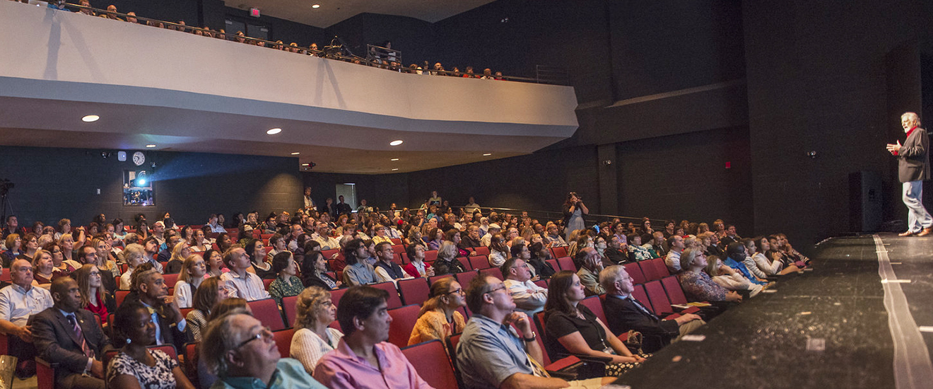 A speaker standing on a stage in front of an audience