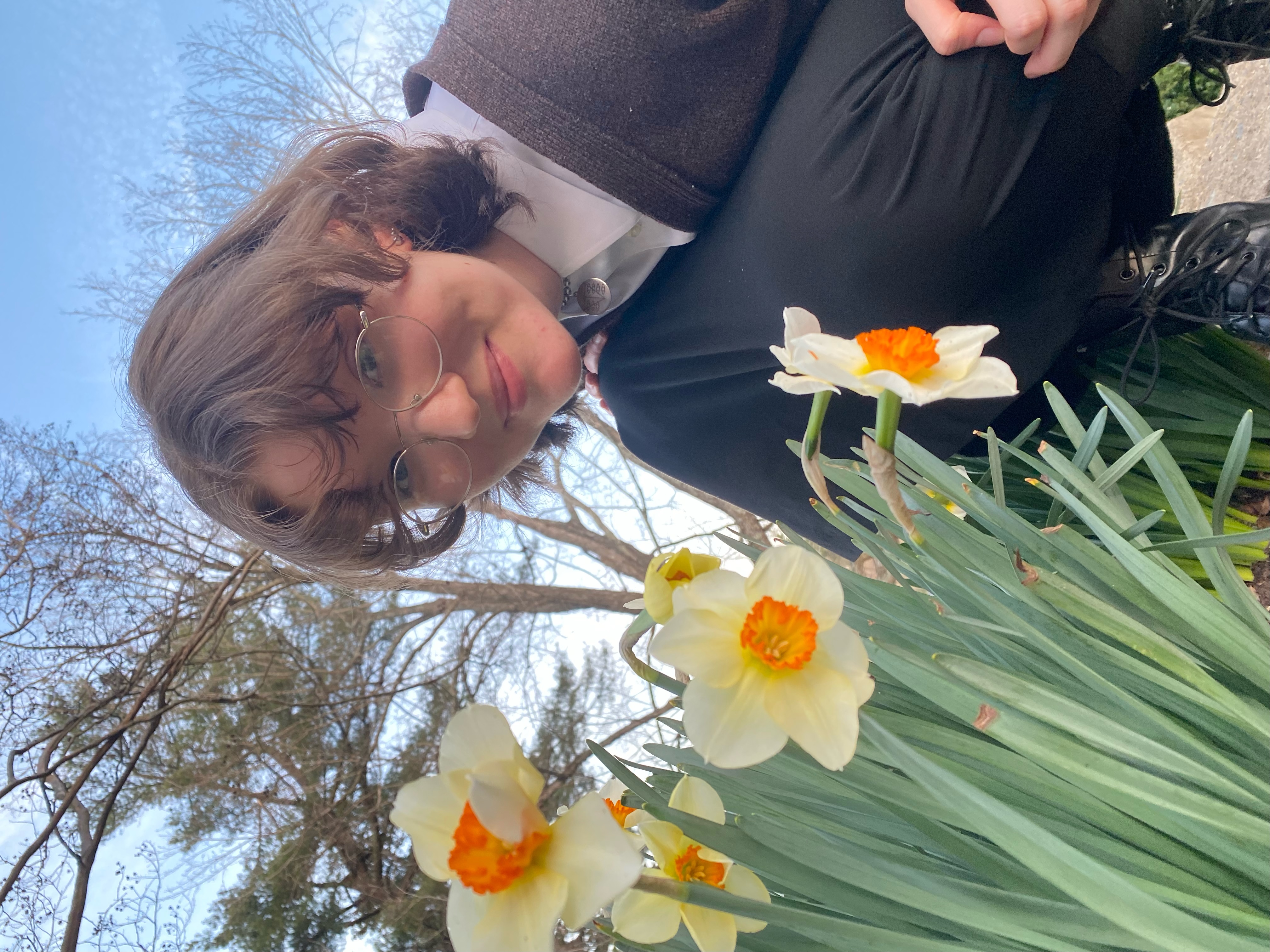 Heather Moser crouching next to some daffodils
