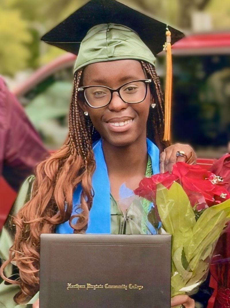 Bianca Watu in college graduation gown and with her diploma