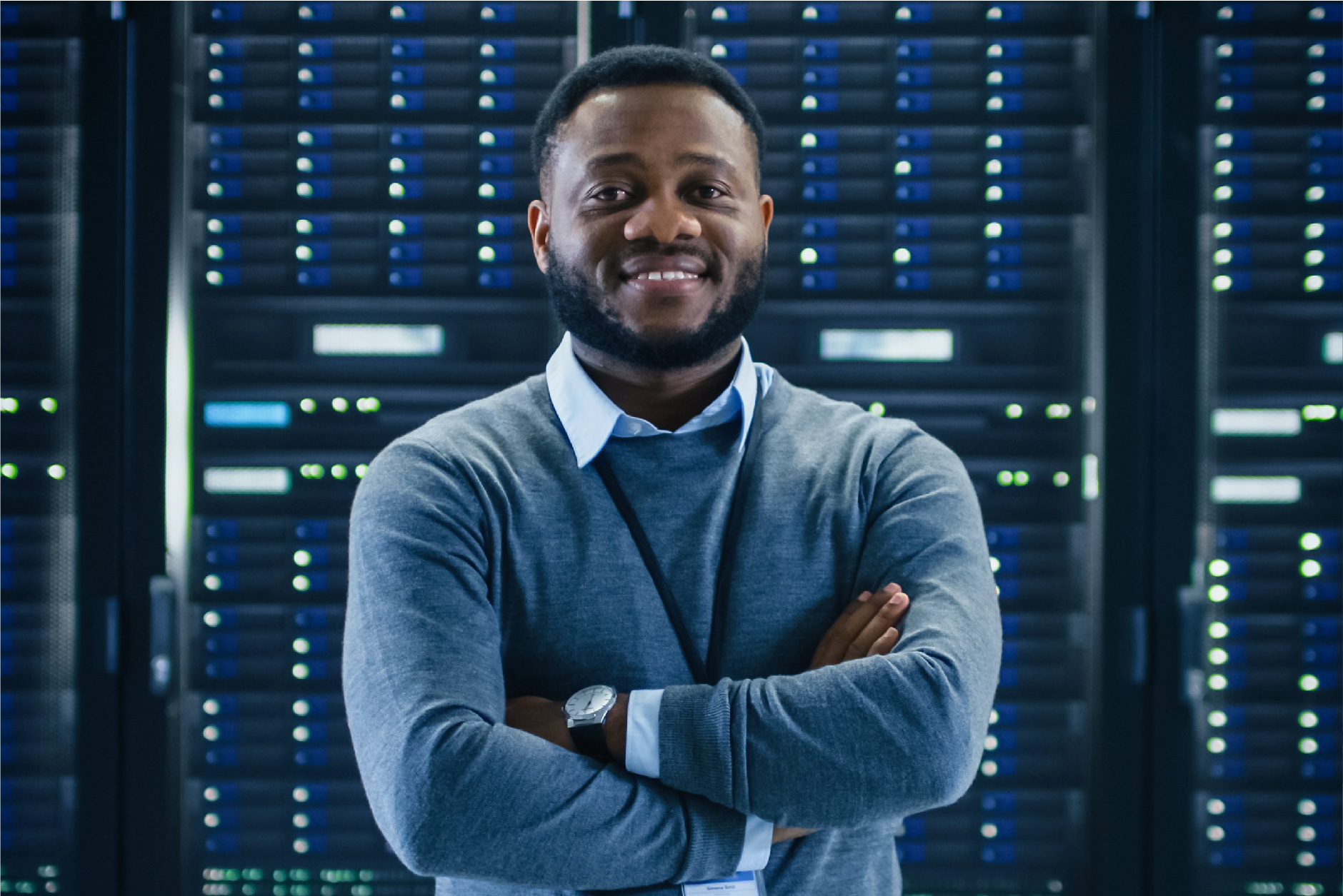 A man standing in front of a large screen covered in data