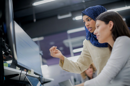 An instructor helping a student at a computer