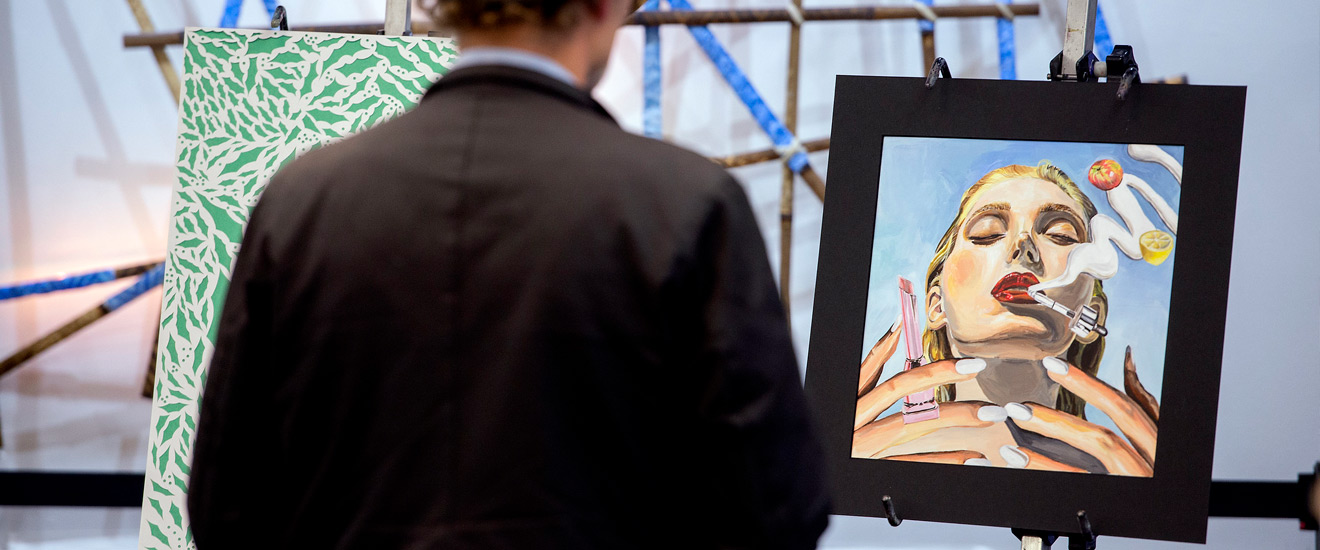 Student standing in front of a painting