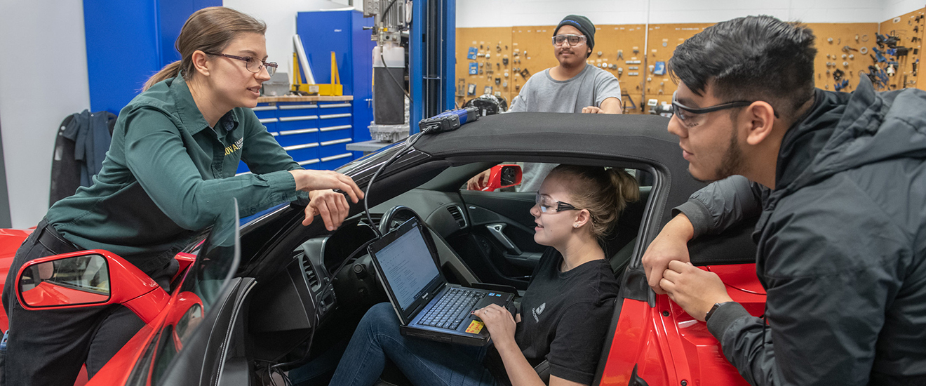 students and instructor working on a car