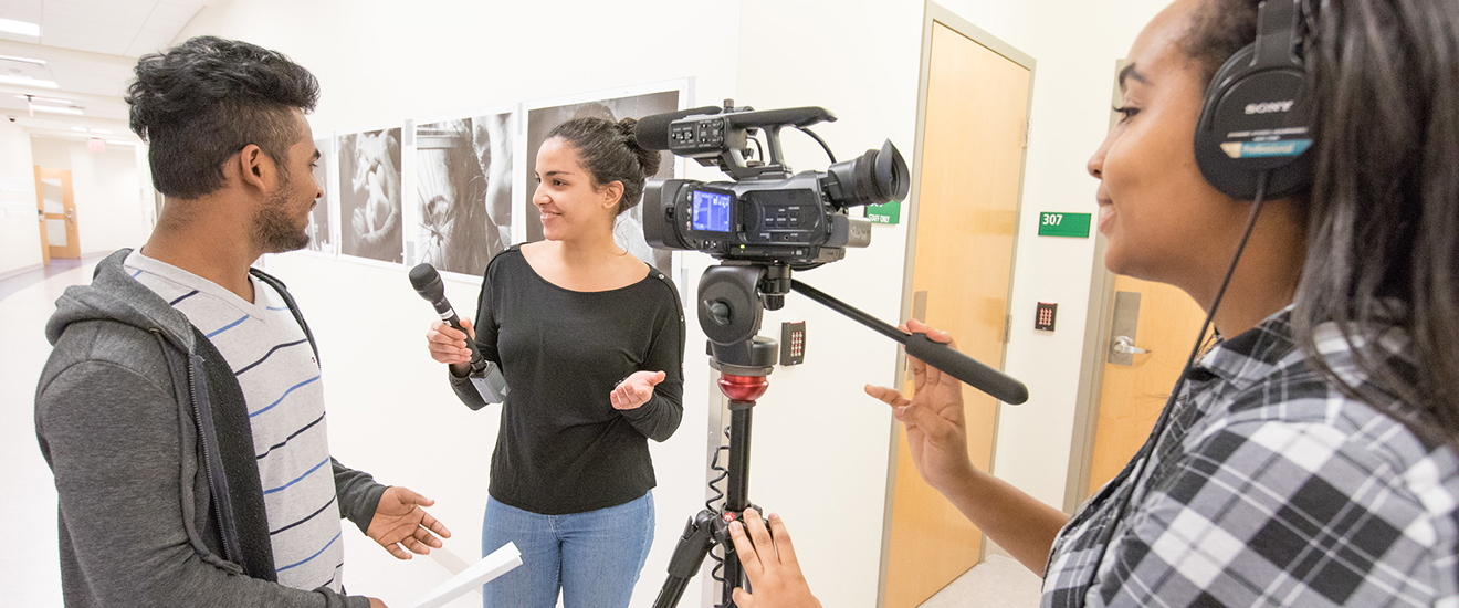 Students working with film equipment conducting an interview