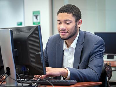student sits in front of computer