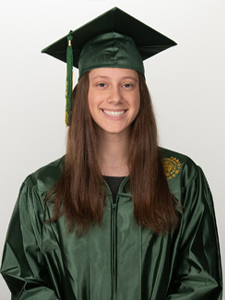 Young woman smiling in a green graduation cap and gown.