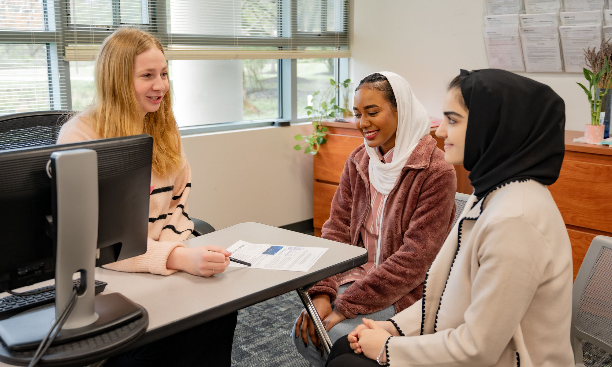 two students meeting with an advisor